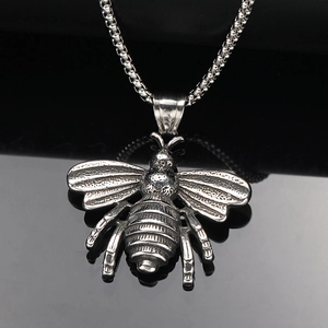 Pendentif bourdon rétro en acier inoxydable avec ailes détaillées sur fond noir