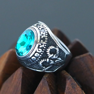Macro shot of a vintage punk ring with a large oval teal gemstone and embossed details