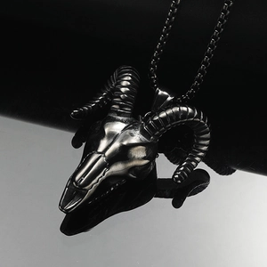 Detailed macro view of vintage ram skull pendant with textured horns on dark reflective surface