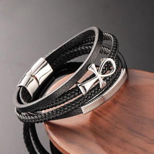 Men's multilayer braided leather bracelet with stainless steel Ankh cross on a wooden background