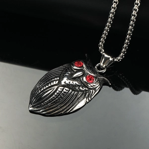 Retro stainless steel owl pendant necklace with red crystal eyes on black surface