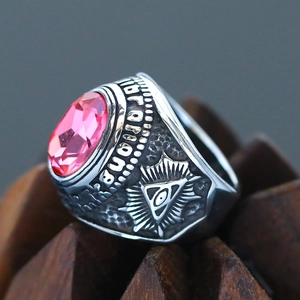 Macro detail of silver punk ring with large pink gemstone and masonic carvings
