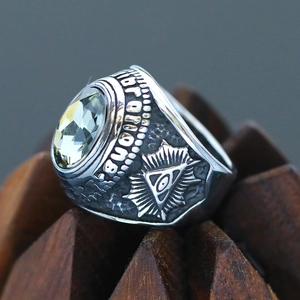 Macro detail of Freemasonry All-Seeing Eye carving and yellow gem on men's ring