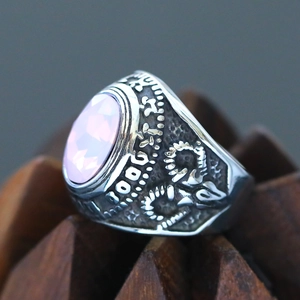 Macro shot of vintage silver ring with pale pink gemstone and intricate relief texture