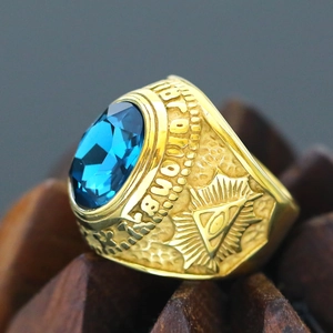 Close-up of golden Masonic ring with large oval blue gemstone and Eye of Providence