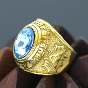 Macro detail showing an oval blue gemstone on a gold-plated Masonic brotherhood ring