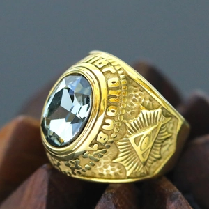 Macro detail of men's vintage gold ring with oval grey gemstone and Eye of Providence carving