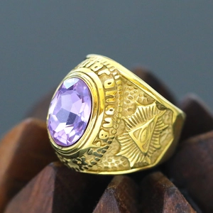 Macro view of gold punk ring with purple gemstone and Masonic All-Seeing Eye carving