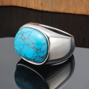 Macro shot of silver wide-band ring featuring an oval flat-top turquoise with mesh texture