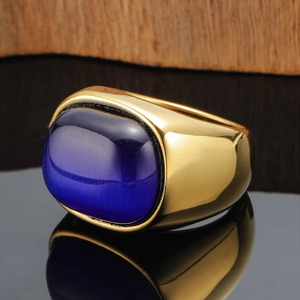 Gold plated wide band ring featuring a large deep blue cat eye stone on black mirror