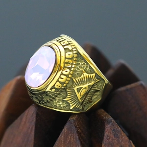 Macro shot of punk style titanium steel ring with pink gem and All-Seeing Eye relief
