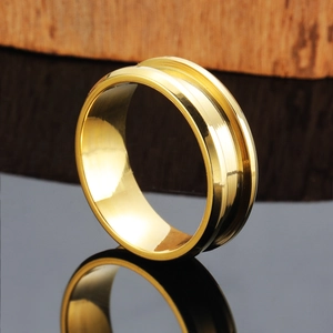 Polished gold stainless steel ring with center groove displayed on black mirror surface