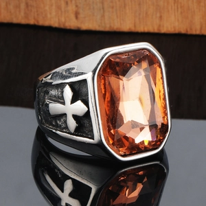 Makroaufnahme eines Punk-Rings aus Titanstahl mit orangefarbenem Stein und Kreuz