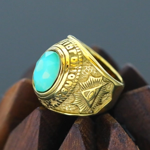 Macro shot of gold punk ring featuring turquoise gemstone and Masonic All-Seeing Eye engraving