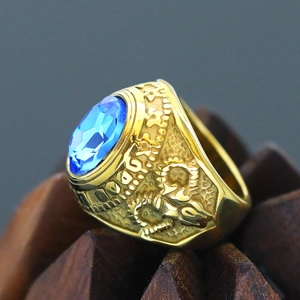 Macro detail of men's retro steel ring featuring an oval blue gem and gold relief textures