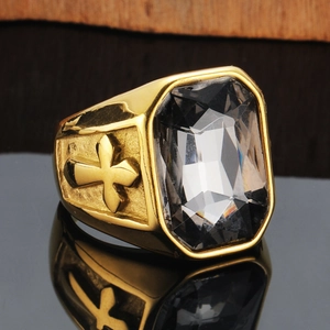 Nahaufnahme eines goldenen Titanstahlrings mit rechteckigem Edelstein und Kreuzrelief
