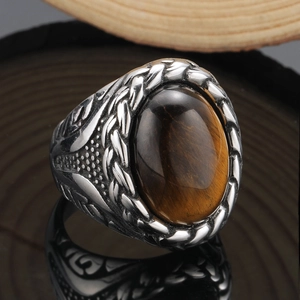 Makroaufnahme eines Vintage-Titanstahlrings mit Tigerauge-Stein und Flechtstruktur