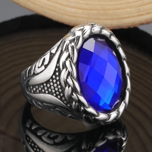 Makroaufnahme eines Vintage Herrenrings mit blauem Edelstein und geflochtener Silbertextur