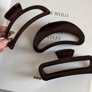 Detailed set of three wood grain hair claws in brown acetate with elegant textures