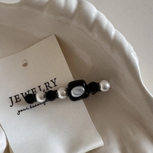 Detail showing vintage French pearl hair clip with black square beads on display card