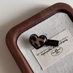 Détail de la pince à cheveux cœur léopard avec lettrage France Handmade doré sur bois