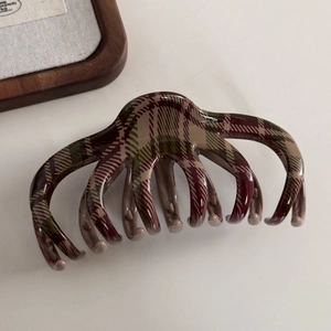 Detail view of the red and green plaid pattern on this elegant acrylic hair claw clip