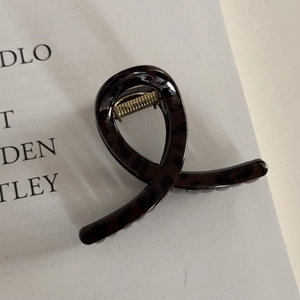 Detail view of leopard print claw clip with shimmering brown finish and golden metal spring