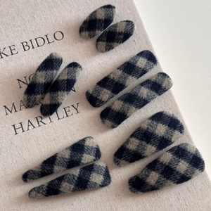Détail de barrettes à carreaux gris en tissu de laine avec un motif vintage