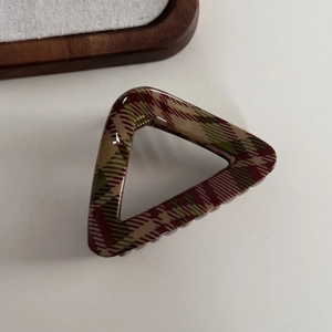Detail view of the vintage checkered hair claw clip with wine red and olive green patterns
