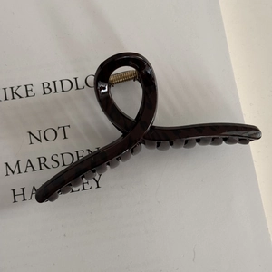 Detail of fine glitter brown leopard print hair claw clip with glossy tortoiseshell texture