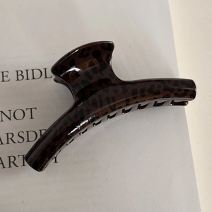Close-up of leopard print hair claw clip made of glossy brown and black resin