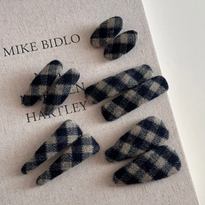 Vue détaillée de barrettes à cheveux en tissu à carreaux bleu marine de formes variées