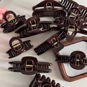 Chocolate brown large hair claw clips with gold labels in various elegant shapes