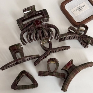 Close-up of vintage red and green plaid hair clips with high-quality gold metal springs
