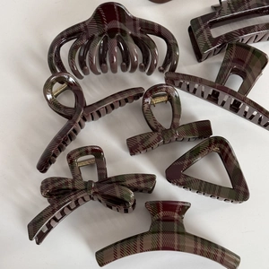 Detail view of various dark red and green plaid hair clips in geometric shapes