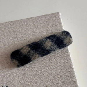 Gros plan détaillé d'une barrette à cheveux rectangulaire à carreaux bleu marine