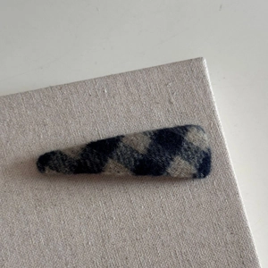 Gros plan sur la barrette à cheveux à carreaux gris avec texture en laine style vintage
