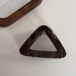 Close-up of dark red and green plaid hair claw clip with a hollow triangle design