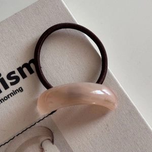 Detailed shot of elastic hair tie with marble resin piece and gold San-shine engraving