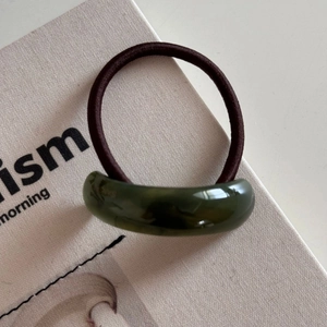 Detail of dark green curved resin hair tie with high-elastic brown rubber band
