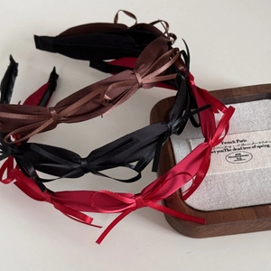Detailed macro view of French silk bow headbands in red, black, and caramel brown colors