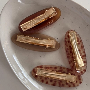 Close-up of four french acetate hair clips with leopard and tortoiseshell patterns