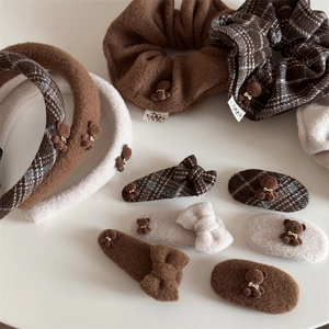 Vue détaillée à plat de pinces à cheveux ours en peluche et chouchous à carreaux marron
