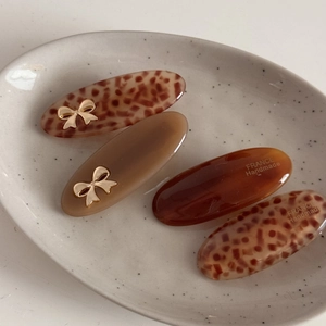 Set of four French acetate bow hair clips in leopard print and amber brown colors