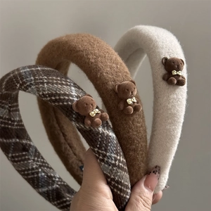 Détail de serre-têtes rembourrés avec ours en peluche, motif à carreaux et polaire