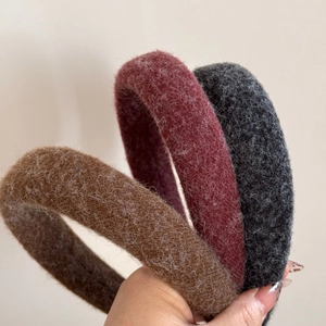 Close-up of brown, red and grey plush scrunchies with soft fuzzy winter textures