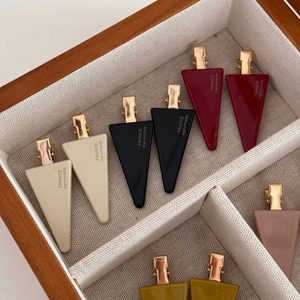 Detail view of handmade French style triangular hair clips in various elegant colors