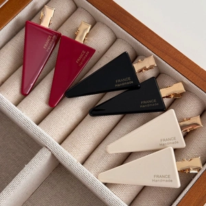 Three-color geometric triangle hair clips in burgundy, black and ivory with gold metal grip