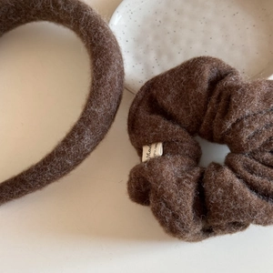 Close-up of deep coffee plush hairband and scrunchie with soft wool-like texture