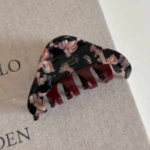 Détail de la pince à cheveux en acétate marbré rose avec logo doré France Handmade